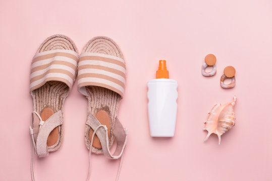 Sun Protection Cream With Female Sandals, Seashell And Earrings On Color Background