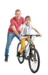 Obraz premium Father and his son with bicycle on white background
