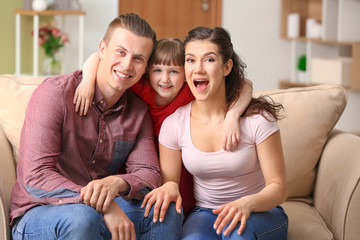 Happy couple with little adopted girl at home