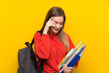 Teenager student girl over yellow background laughing