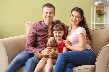 Happy couple with little adopted girl at home