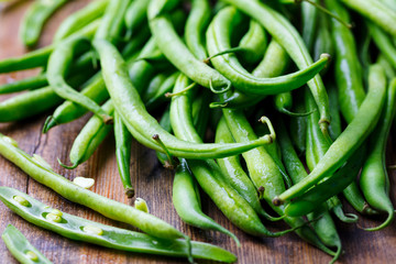 Green beans on wooden cutting board. Go green concept. Close up.