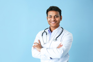 Handsome male doctor on color background