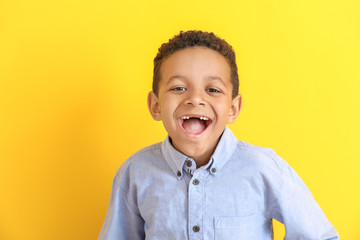 Laughing African-American boy on color background
