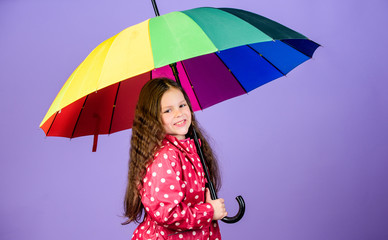 rain protection. Rainbow. happy little girl with colorful umbrella. autumn fashion. little girl in...