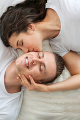 Obraz na płótnie Canvas Adorable loving couple lying in bed