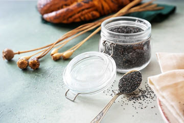 Jar with poppy seeds on table