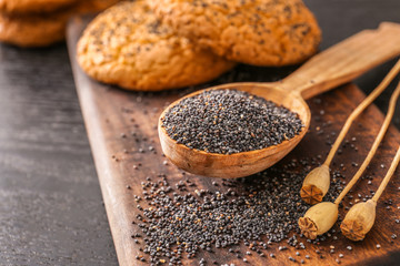Spoon with poppy seeds on table