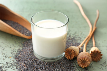 Glass of milk and poppy seeds on table