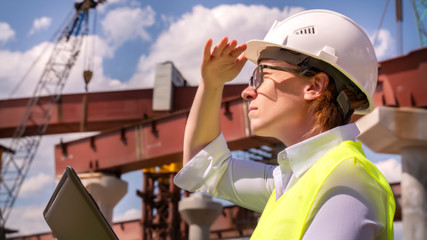 female foreman inspects object at building site. Construction of central ring car road.