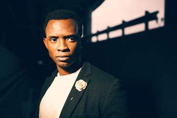 Black guy in a dark suit in a dark room