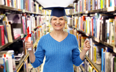 graduation, education and old people concept - happy senior graduate student woman in mortar board...