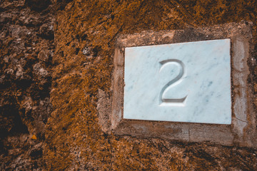 the number 2 on white stone with brown facade