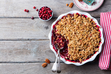 Cranberry crumble, crisp in a baking dish. Wooden background. Top view. Copy space.