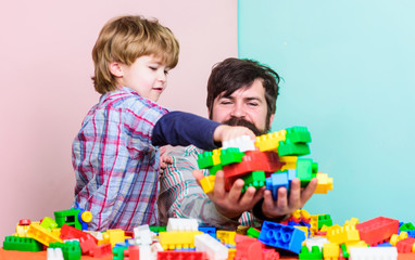 Father son game. Father son create constructions. Father and boy family leisure. Father leader showing boy how grow into successful man. Dad and kid build plastic blocks. Child care and upbringing