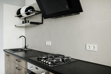 Modern kitchen, close up, gas stove with cooking pan, white and gray minimalistic interior design.