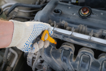 checking the oil level in a car engine