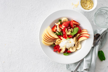 Mixed fruit salad on a white background top view. healthy food plate copy space