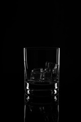 Glass with ice cubes, isolated on a black background