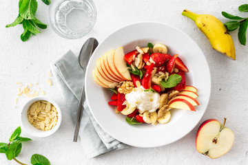 Healthy colourful summer fruit salad on a white background top view. Healthy plate food