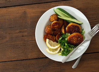 Dinner plate with vegetarian food. Fresh vegetarian cutlets with new potatoes and salad on wooden table top view