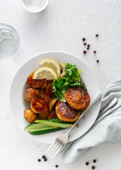 Dinner plate with vegetarian food. Fresh vegetarian cutlets with new potatoes and salad on white background top view