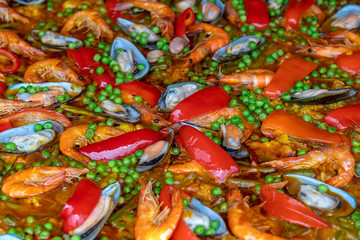 Spanish seafood paella in fry pan with mussels, shrimps and vegetables. Seafood paella background, closeup, traditional spanish rice dish
