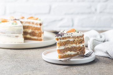 Healthy homemade carrot cake with cream cheese frosting on light stone background
