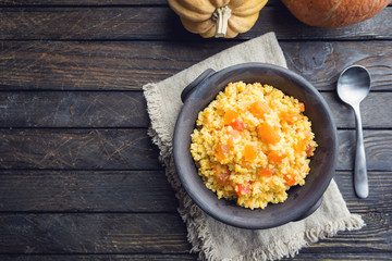Millet porridge with sweet pumpkin in a bowl, rustic style. Healthy vegan dish. top view