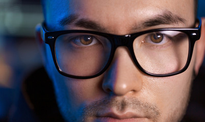 vision, hacking and people concept - close up of asian male hacker's face in glasses