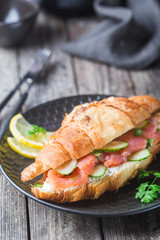 smoked salmon sandwich with cream cheese fresh and cucumbers on black plate