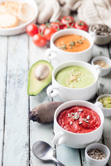 Variety of different colorful vegetable cream soups in a bowls. Concept of healthy eating or vegetarian food.