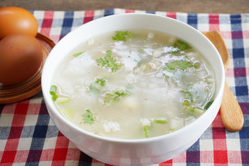 Breakfast boiled rice with pork and three eggs on the table.