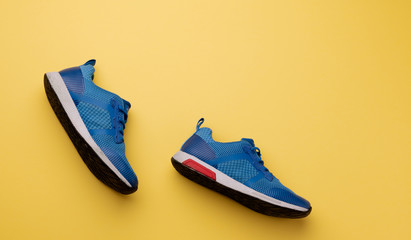 A studio shot of pair of running shoes on yellow background. Flat lay.