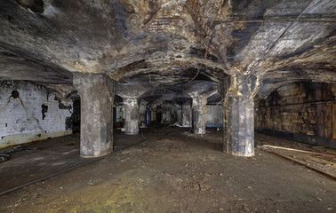 Interior of an abandoned underground wine warehouse of the 19th century. Room with columns