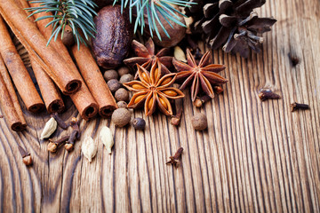 Christmas winter spices and blue pine tree branch on wooden background. Copy space.