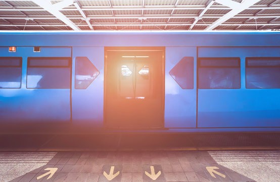 blue color Train is open the door while ariving station. Sign get in and go out for BTS sky train on platform