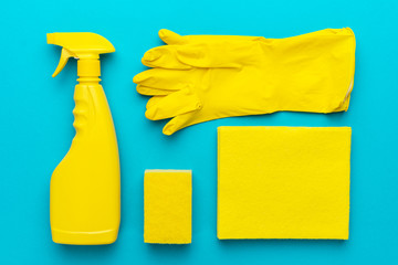 yellow cleanser in plastic container with spray, rubber protective gloves, sponge and cloths for...