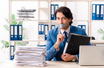 Young male employee with tape on the mouth 