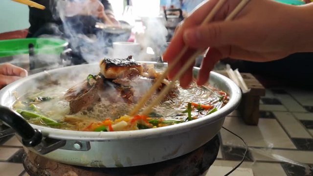 pork on a hot plate vegetable and soup on hot pan ,Moo Katha barbecue Thai food.