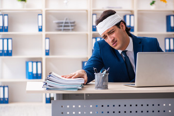Head injured male employee working in the office 