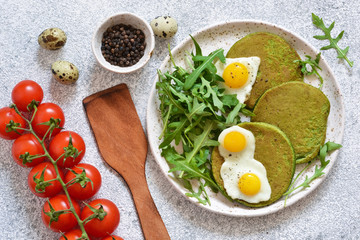 Morning breakfast: pancakes with spinach, salad and egg on the kitchen table. View from above.