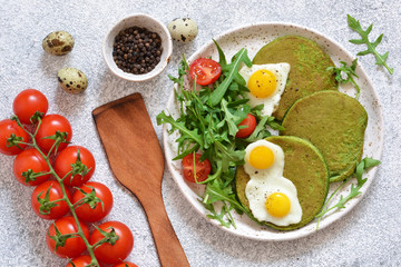 Morning breakfast: pancakes with spinach, salad and egg on the kitchen table. View from above.