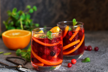 Cold cranberry juice with orange and mint. Summer drink.