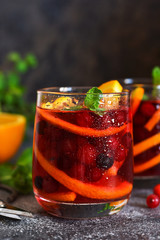 Cold cranberry juice with orange and mint. Summer drink.