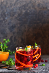 Cold cranberry juice with orange and mint. Summer drink.