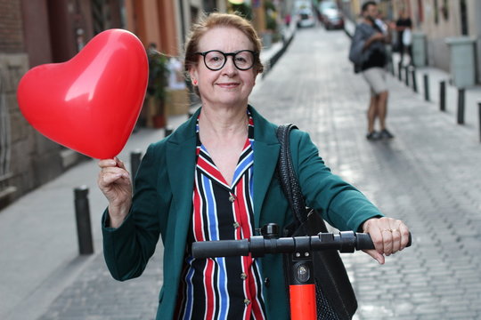 Mature woman loving her electric scooter  - Powered by Adobe