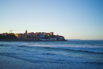 Fototapeta premium San Pedro's Church (Iglesia de San Pedro) with the Cantabrian Sea in San Lorenzo beach, Gijon, Asturias (Spain)