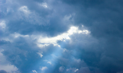  Close-up of rays of sunlight through puffy clouds