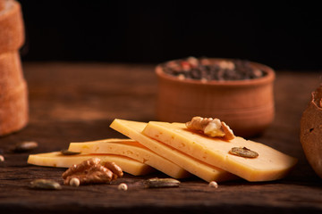 Peppercorns in a wooden bowl on table with cheese. Homemade food